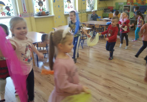 Dzieci biorą udział w zabawie ruchowej z chustą.
